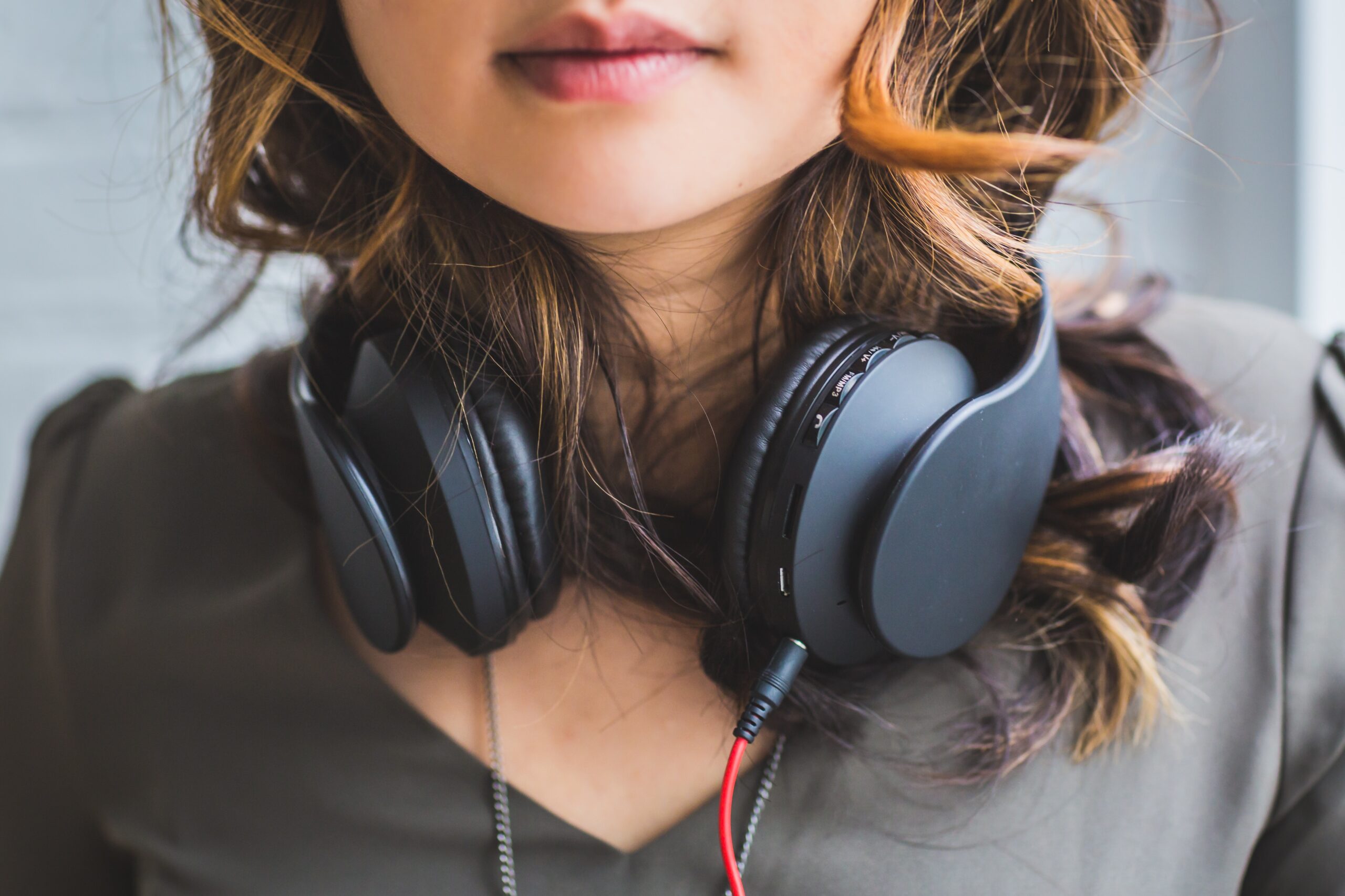 Sound quality and podcasts. Girl with headphones around neck.